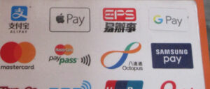 A retail payment-methods sign showing accepted payment logos including Mastercard and Mastercard PayPass, at a store in Hong Kong.