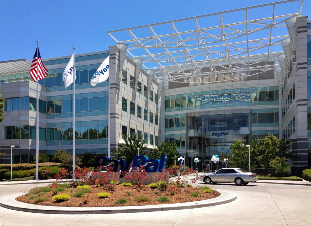 PayPal headquarters building in San Jose, California, with a large PayPal sign on the ground marker and PayPal branding visible on the entrance.